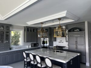 Luxury kitchen remodel featuring dark custom cabinets, marble island, and elegant pendant lighting.